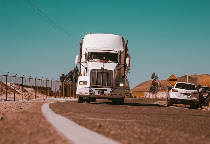 white freight truck on grey concrete road