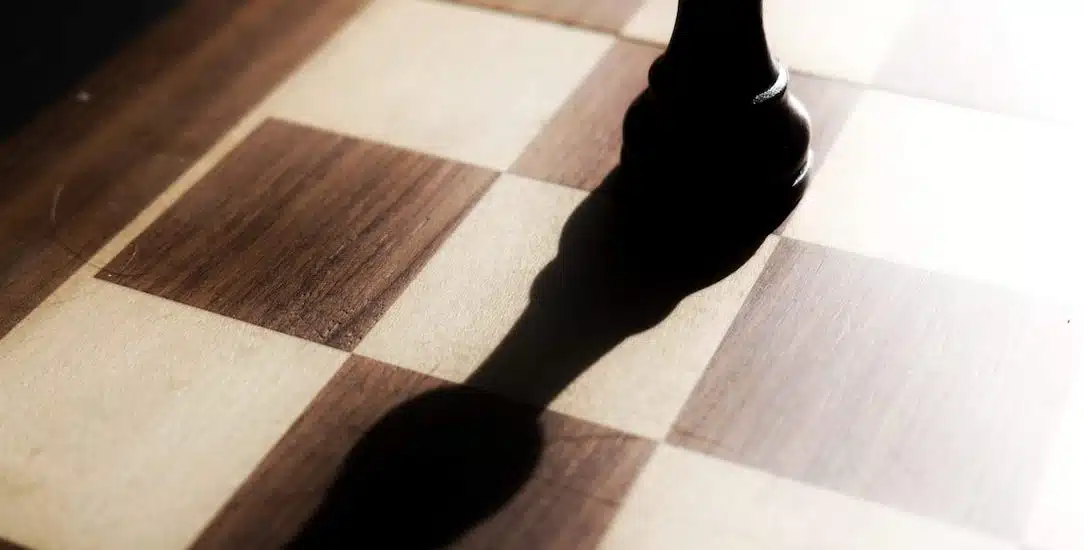 black chess piece on brown and white checkered table