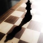 black chess piece on brown and white checkered table