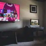 black flat screen tv turned on near black wooden table